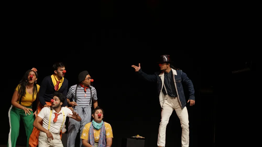 Performers react to a character in a top hat
